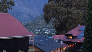 A building with a red roof, solar panels, and a stone wall.