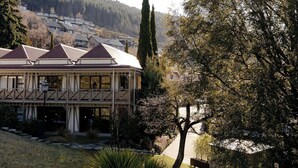 A building with a traditional architectural style, featuring a symmetrical facade with a central entrance and a series of windows. - Sherwood Queenstown (Queenstown)