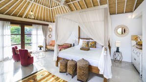 A spacious bedroom with a large bed, a canopy, and a view of greenery outside. - Calma Ubud (Ubud)