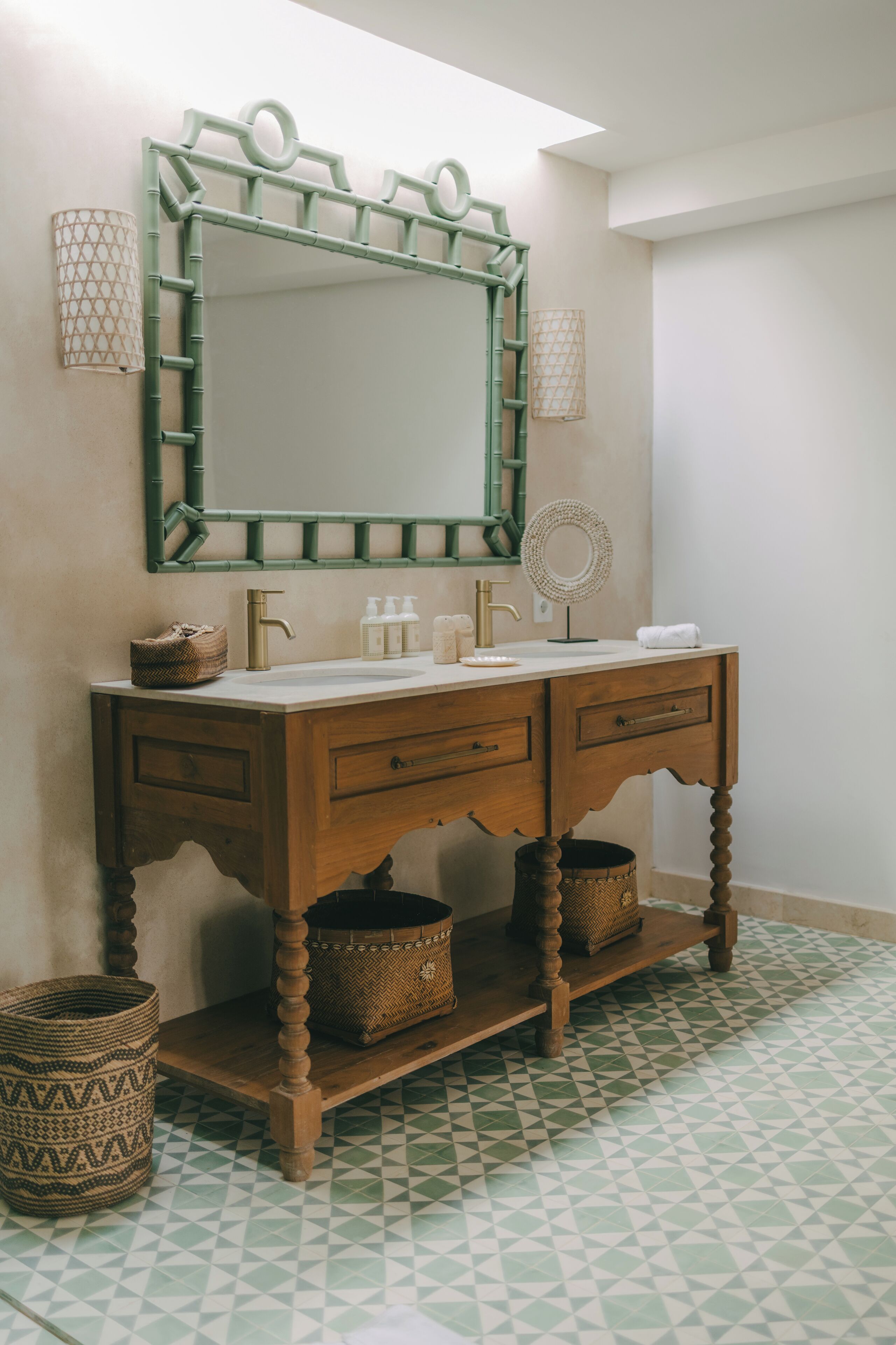 Une salle de bain avec un meuble-lavabo en bois, un grand miroir et un carrelage décoratif.