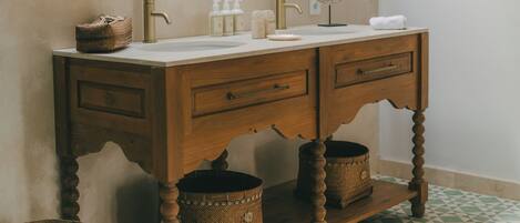 Une salle de bain avec un meuble-lavabo en bois, un grand miroir et un carrelage décoratif.