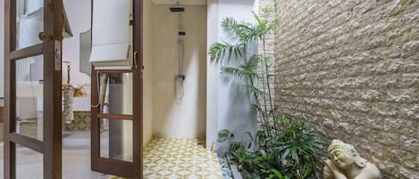 A bathroom with a shower, a towel rack, and a statue.