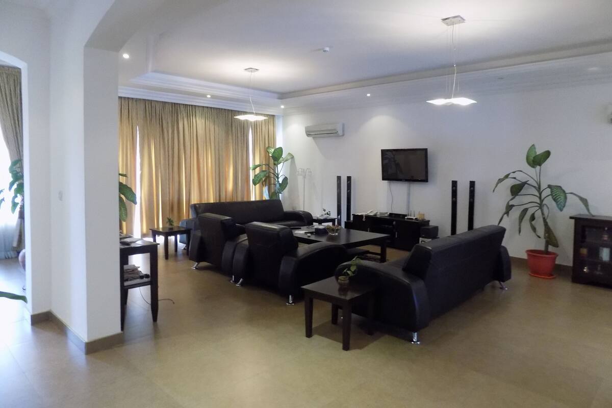 Una sala de estar moderna con un juego de sofá, una mesa de centro y un televisor montado en la pared.