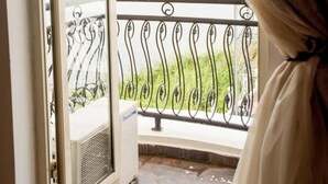An open balcony door with a view of a body of water and a distant structure. - The Gilgal Guest House (Lekki)