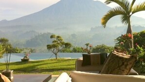 A serene outdoor seating area with a view of a mountain and a lake. - Villa Sidemen (Sidemen)