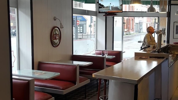 A restaurant with booths, a bar area, and a view of the street.