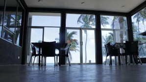Una habitación amplia con ventanas grandes, una mesa de comedor y sillas.