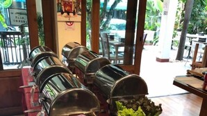 A buffet setup with multiple serving stations, a floral centerpiece, and various food and drink options. - Vieng Mantra (Chiang Mai)