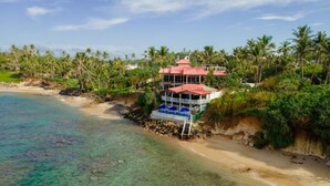 Une propriété située en bord de mer, dotée d’une structure à plusieurs niveaux, d’une piscine et offrant une vue sur l’océan.