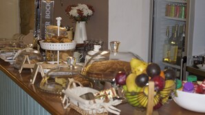 A buffet table with various food items and a fruit bowl. - Belos Aires Apartments (Porto)