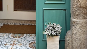 A teal door with a wooden paddle sign reading "Belos Aires" and a framed menu. - Belos Aires Apartments (Porto)