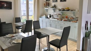 A dining area with a table and chairs, a kitchen with a breakfast bar, and a balcony with a view. - Bella Tropea Accommodation (Tropea)