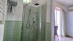 A bathroom with a glass-enclosed shower, a toilet, and a towel rack. - Bella Tropea Accommodation (Tropea)