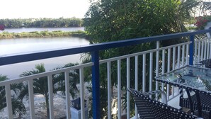 A balcony with a view of a lake, surrounded by greenery and a railing. - Tra Que Riverside Homestay (Da Nang)