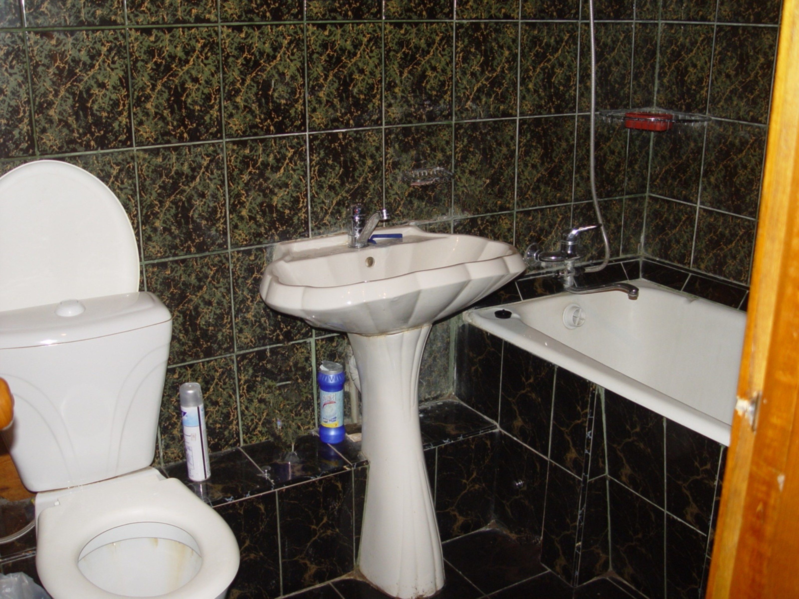Une salle de bain avec des toilettes, un lavabo et une baignoire.