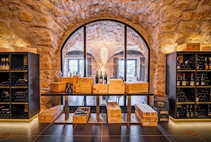A wine cellar with wooden crates and shelves of wine bottles.