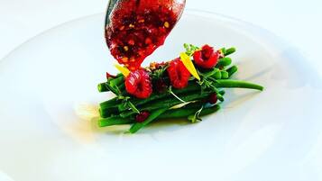 A white plate with a spoonful of red sauce and green vegetables.