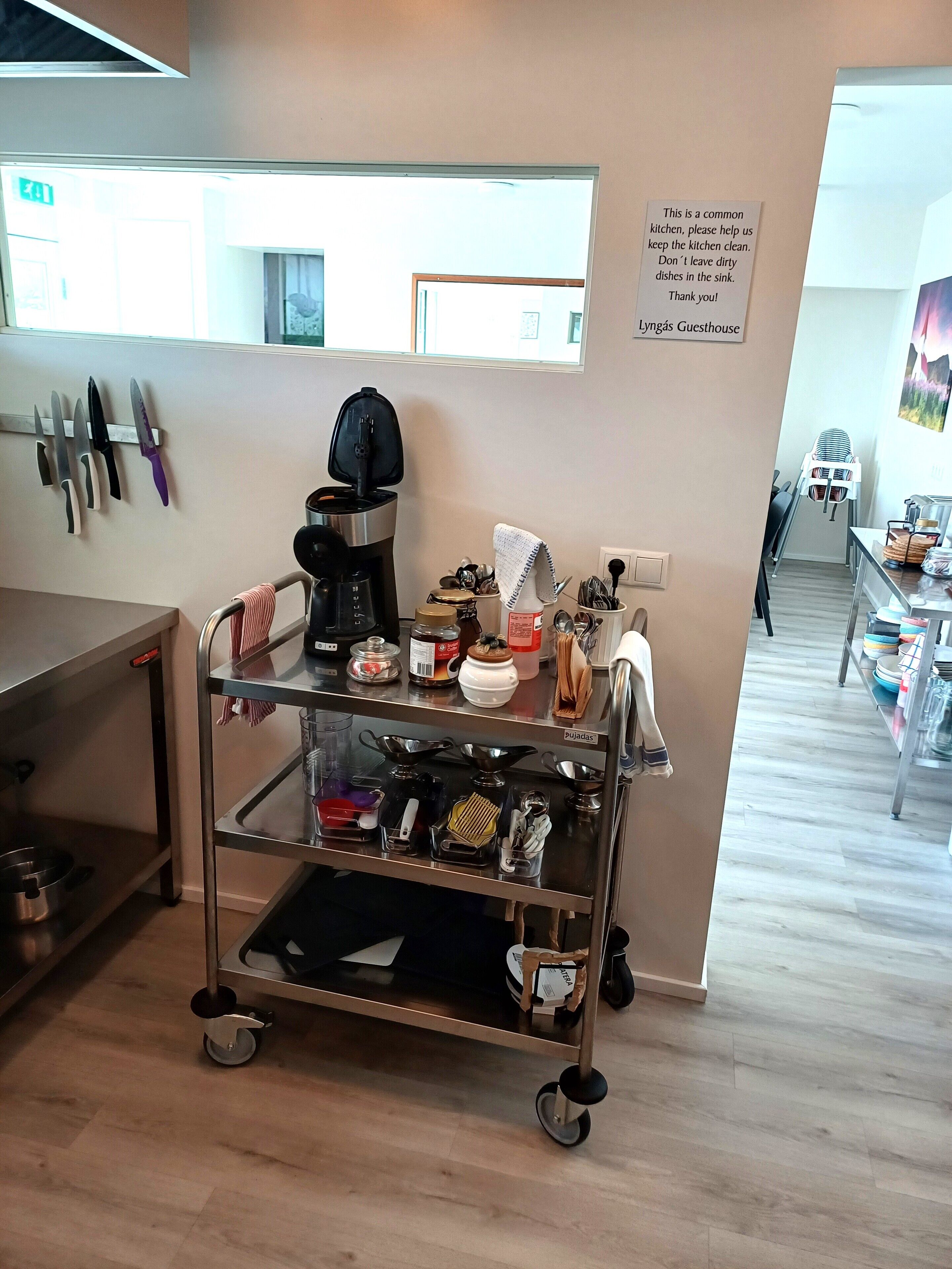 Un coin cuisine équipé d’une machine à café, d’ustensiles et d’un panneau invitant les clients à maintenir la propreté de la cuisine.
