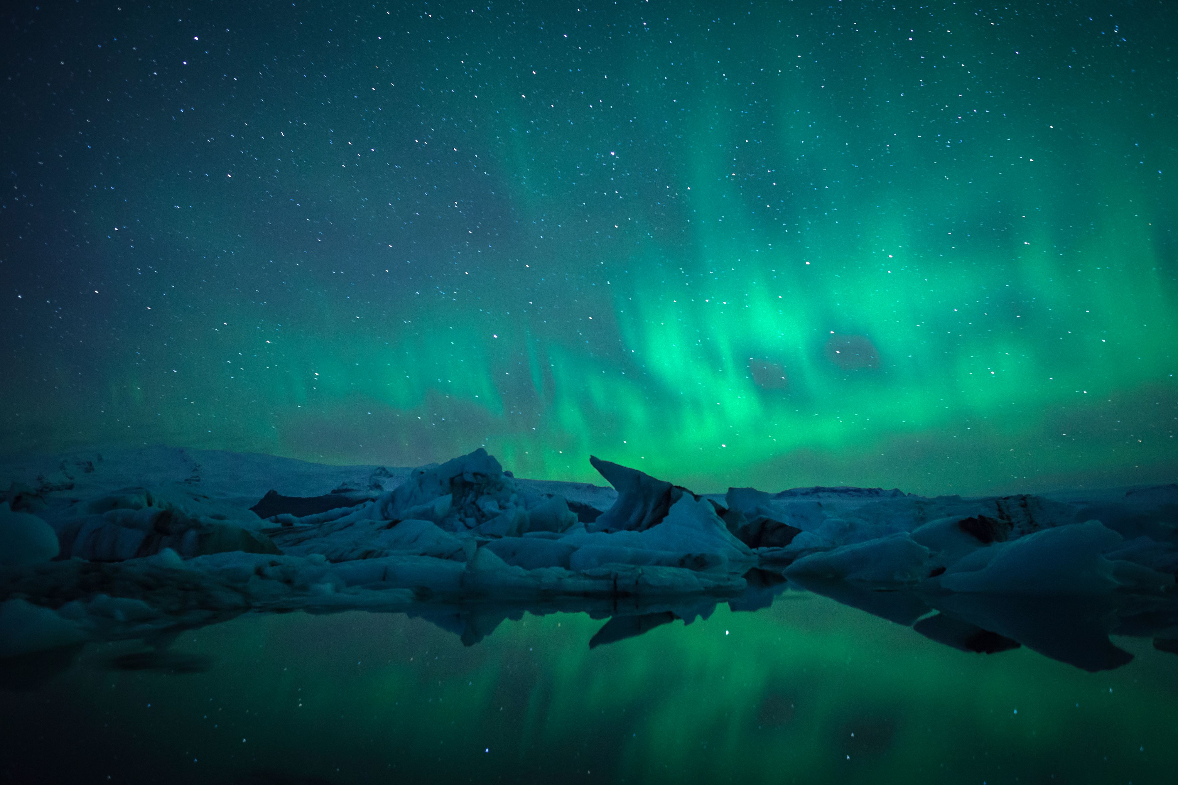 A night sky with the Northern Lights over a frozen landscape.