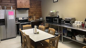 Una cocina equipada con refrigerador, estufa, microondas, tostadora y cafetera.