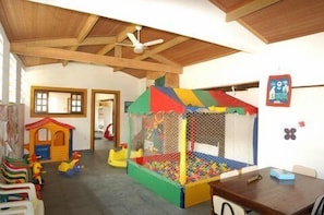 A play area with a small playhouse and a ball pit.