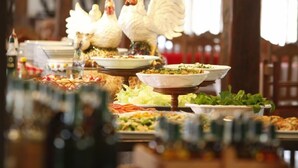 Una mesa de bufé con diversos platos y una estatua decorativa de gallo.
