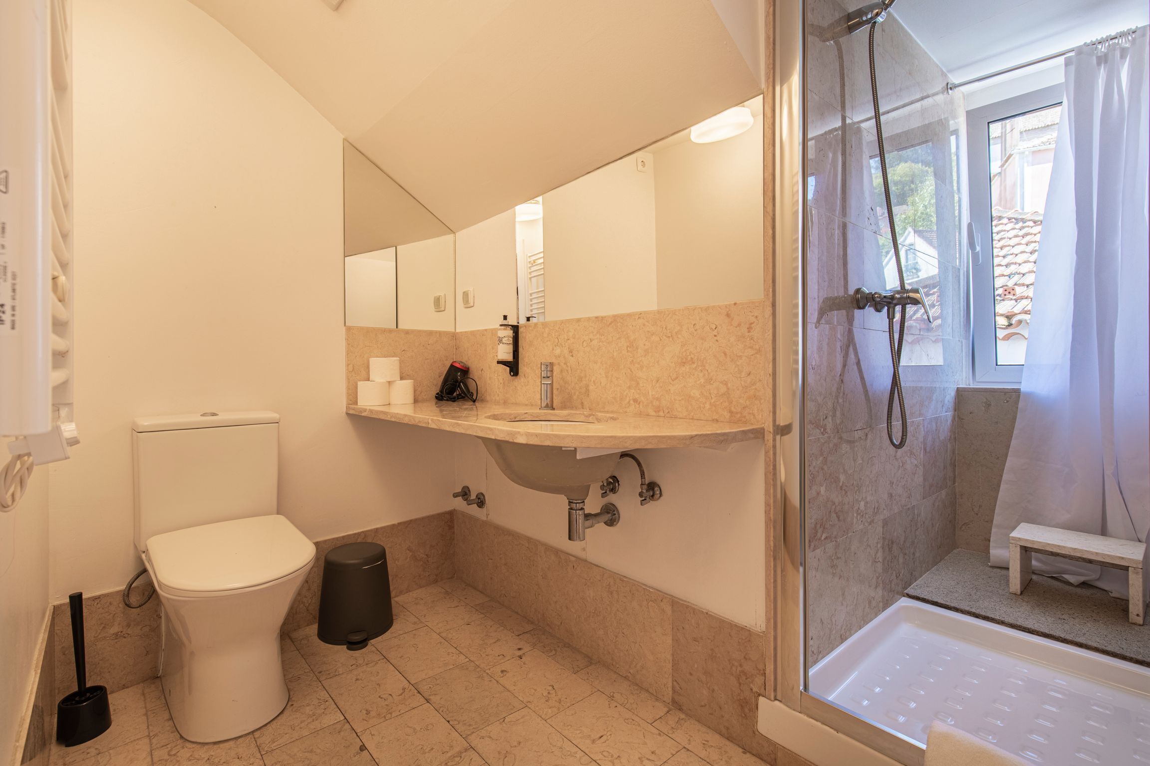Een badkamer met toilet, wastafel en douche.