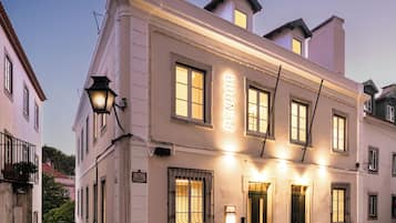 Un edificio histórico con un letrero que dice 'PENDORA' en la fachada, una calle adoquinada y un farol tradicional.