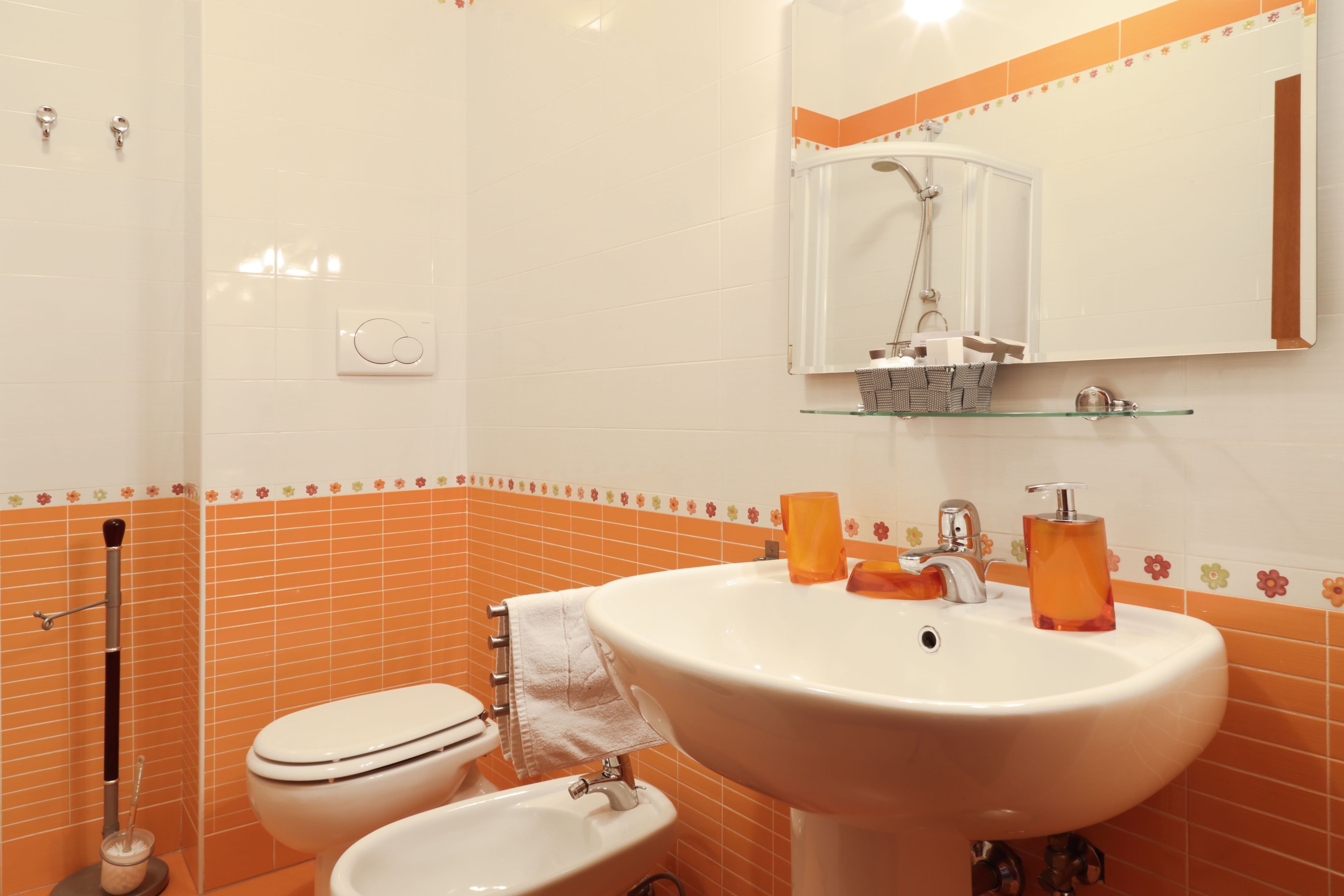 Un baño con lavamanos blanco, inodoro y ducha.