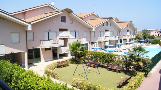 A residential building with a swimming pool, a children's play area, and a well-maintained garden. - Polena Residence Hotel (Montenero di Bisaccia)