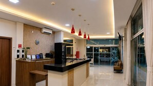 A modern kitchen with a central island, a reception desk, and a glass door entrance. - Mac Hotel (Palmas)