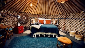 A yurt-style room with a bed, a small table, and a chair. - Wester Auchraw Croft B&B (Lochearnhead)