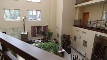 A multi-level interior with a central atrium, featuring a fireplace, dining area, and multiple windows.