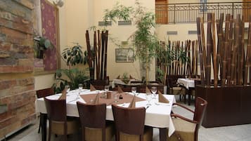A restaurant with round tables, wooden chairs, and bamboo decorations.