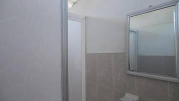 A bathroom with a mirror, tiled walls, and a white sink.