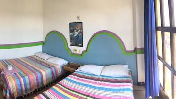 A room with two beds, a window with curtains, and a door.