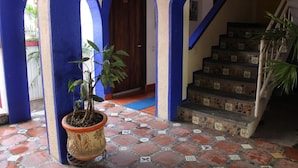 A building entrance with blue arches, a staircase, and a potted plant. - Pargo's Hotel (Puerto Escondido)
