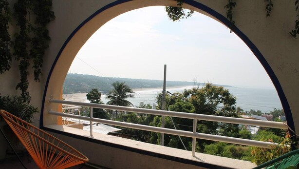 A balcony with a view of the sea, a chair, and a hammock. - Pargo's Hotel (Puerto Escondido)