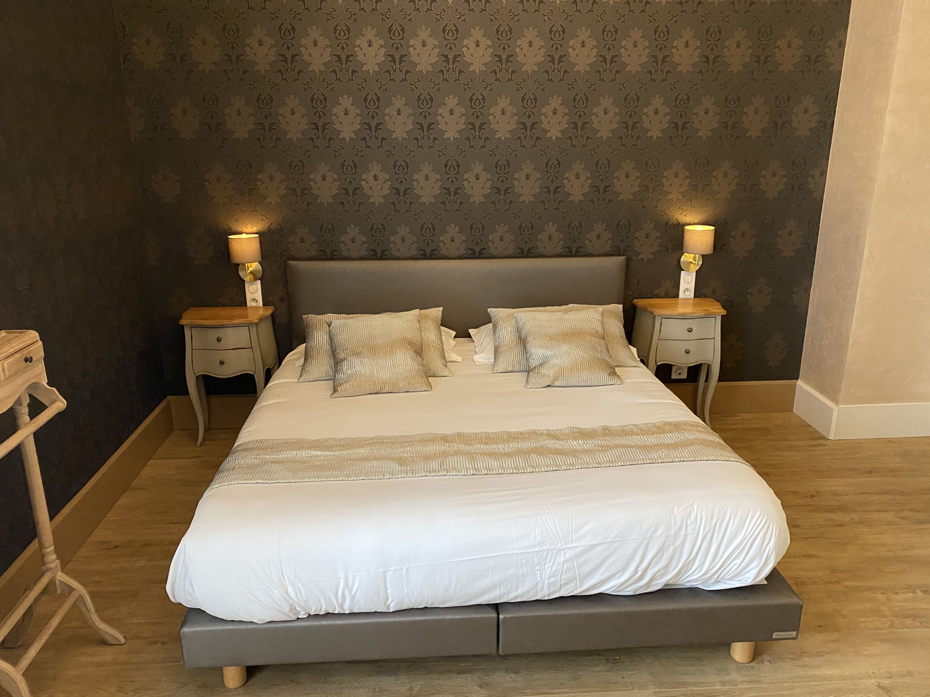 A bedroom with a large bed, two bedside tables, and a nightstand.