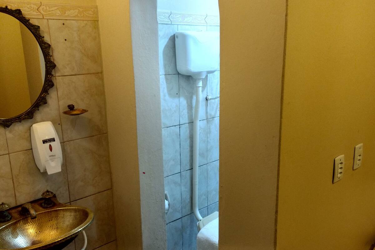 Een badkamer met een wastafel, spiegel en handdroger.
