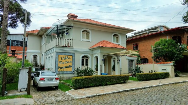A two-story building with a sign reading "Villa Cezar Pousada".