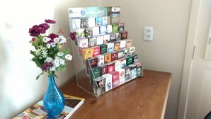 Une collection de cartes de vœux et un vase bleu rempli de fleurs sont disposés sur une table en bois.