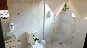 A bathroom with a toilet, sink, and shower area.