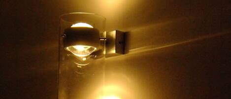 A wall-mounted light fixture with a glass enclosure and a visible bulb.