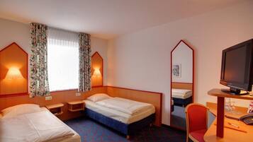 A hotel room with two beds, a desk with a chair, a TV, and a mirror.