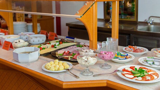 Ein Buffet mit verschiedenen Speisen, darunter Salate, Pasta und Desserts.