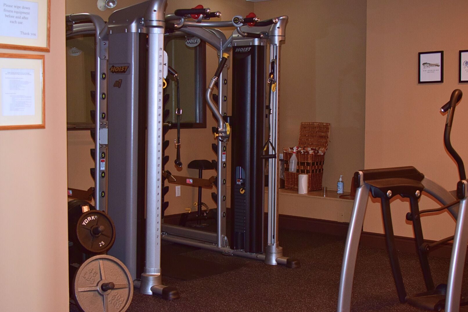 A gym with a weight machine, a treadmill, and a wall-mounted exercise bike.