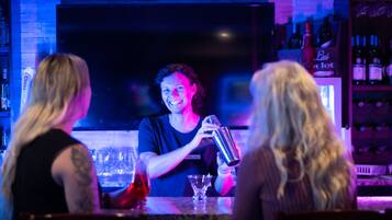 A bar with a bartender preparing drinks.