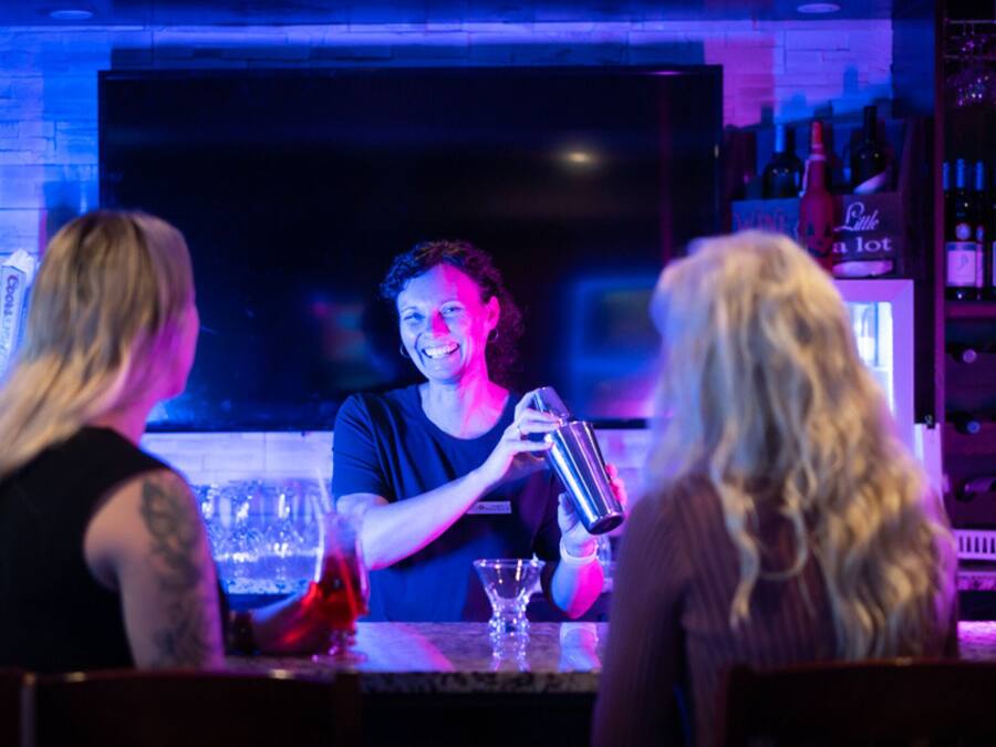 A bar with a bartender preparing drinks.