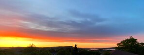 A sunset over a hilly landscape with a road and trees in the foreground. - Clarenville Inn (Clarenville)
